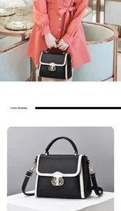 Détail du sac à main en cuir noir avec bordure crème et fermoir doré chic