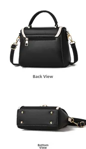 Détails du sac à main en cuir noir avec bordure crème, fermeture éclair et clous de protection