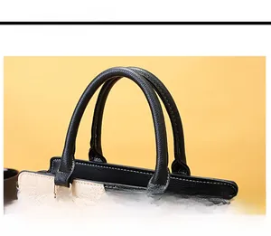 Dettaglio delle cuciture e della trama della pelle su una borsa bicolore beige e nera