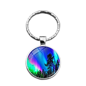 Détail du porte-clés cabochon aurore boréale avec silhouette de forêt et métal argenté