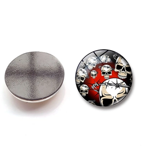 Detail of 25mm round glass magnet featuring a skull and barbed wire gothic art pattern