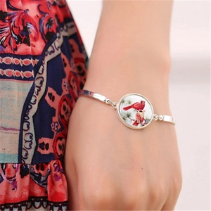 Silver bracelet featuring cardinal birds in a glass pendant on a松松 silver chain style