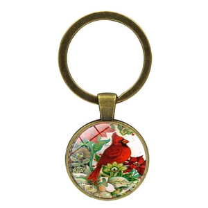 Detail of cardinal bird glass cabochon pendant with bronze metal keyring finish
