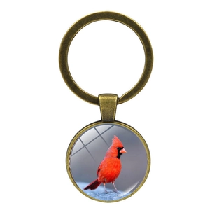 Detail of vintage bronze cardinal bird keychain with convex glass cabochon pendant