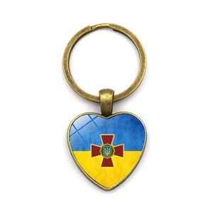 Détail du porte-clés cœur drapeau Ukraine avec cadre en bronze et emblème militaire