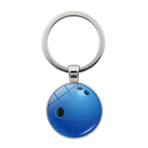 Detalle de llavero de bola de bolos azul con cabujón de cristal y aro metálico pulido