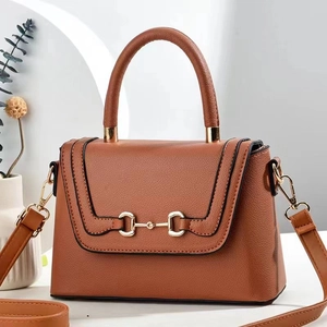 Detail der braunen Lederhandtasche mit Lychee-Struktur, Gebiss-Schnalle und Rundgriff
