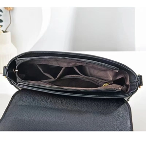 Innendetails der schwarzen Lederhandtasche mit braunem Futter und Reißverschlussfach