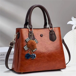 Vintage brown leather tote bag with round handles and tassel charm for women