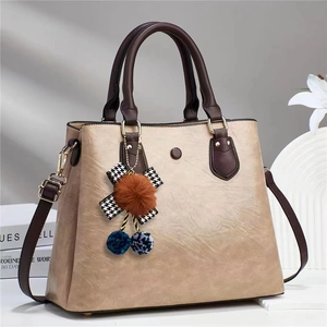 Minimalist large-capacity faux leather handbag in khaki with brown handles and plush charm