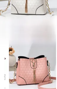 Detail of pink and beige bucket bags with geometric texture, cat clasp, and tassel