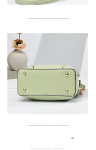 Detail of light green bucket bag base with four golden metal feet and diamond stitching