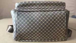Detail view of a large capacity grey shoulder bag with yellow geometric diamond pattern