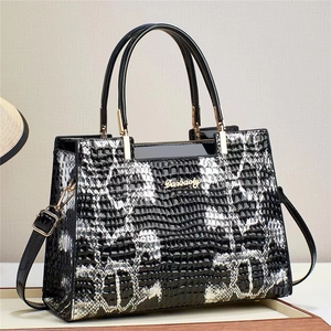 Black and white faux snakeskin tote bag with glossy handles and gold metal hardware