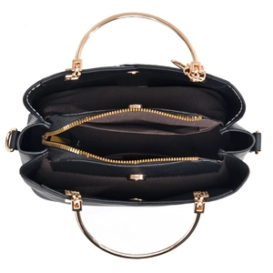 Interior view of black bucket bag featuring golden circular handles and brown fabric lining
