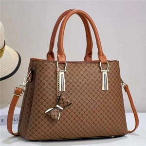 Sac à main caramel avec imprimé croisé, garnitures dorées et pendentif nœud élégant