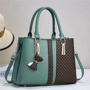 Green and brown patchwork handbag with adjustable shoulder strap and bow charm