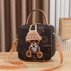 Brown box-shaped crossbody bag with vintage print and a plush bear with a knit hat