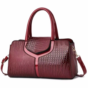 Deep red crocodile embossed leather handbag with glossy finish and top handles