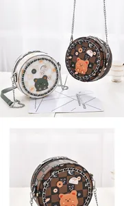 Detail of round crossbody bags with checkerboard patterns and cute cartoon cat embroidery