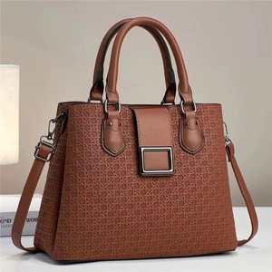 Détail de la texture gaufrée et boucle métallique sur le sac à main en cuir marron