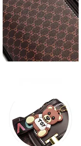 Close-up of DH jacquard fabric texture and cute toy bear charm on brown handbag