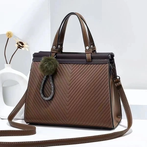 Brown embossed tote bag with V-pattern, round handles, and detachable shoulder strap