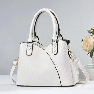 Detail of white faux leather handbag showing fine litchi texture and gold hardware