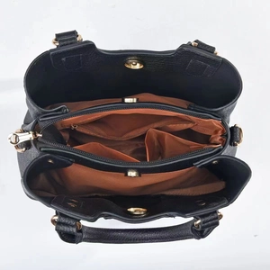 Detail view of large capacity multi-layer handbag interior with brown lining and gold hardware