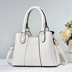 Detail of white lychee leather texture with black edge piping and gold hardware