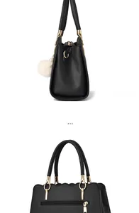 Detail view of black faux leather tote featuring wavy edges and golden hardware accents