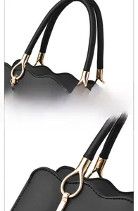 Detail of soft black leather handbag with wavy edge and gold teardrop hardware