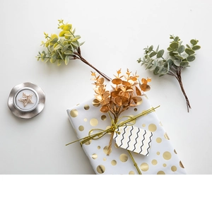 Artificial eucalyptus leaves used as elegant decoration on a gift box with gold cord