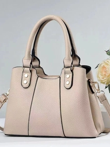 Elegant beige pebbled leather handbag with top handles and adjustable shoulder strap