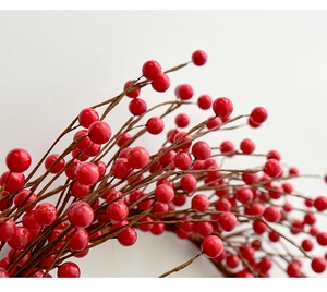 Detailed close-up of vibrant red artificial berries with realistic branch texture for Christmas