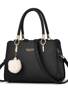 Minimalist black faux leather handbag with wave cut edge and fluffy charm detail