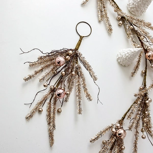 Ghirlanda di Natale oro champagne con ornamenti rosa e aghi di pino glitterati