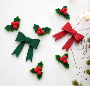 Close-up of DIY Christmas felt decorations with red bows and green holly leaves with berries