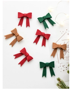 Handmade Christmas felt bow decorations in red green and brown for DIY festive ornaments