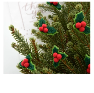Detail of DIY Christmas holly decoration with red berries and green felt leaves