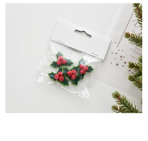 Detail of DIY Christmas holly leaf and red berry decorations for festive tree styling