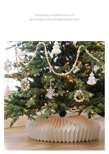 Detail of white pleated Christmas tree skirt and natural wooden bead ornaments set