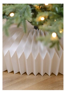 Macro detail of white pleated Christmas tree collar skirt on light wood floor setting