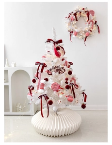 Detail of white Christmas tree with red bows, ornaments and Merry Christmas sign