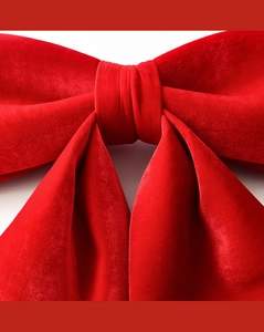 Macro shot of red velvet Christmas bow showing soft fabric texture and pleated center knot