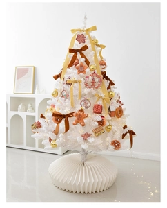 Detail of white Christmas tree with gingerbread ornaments, gold ribbons and pleated tree skirt