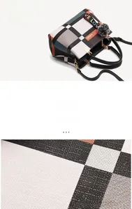 Macro view of plaid pattern handbag with hardware logo and decorative love strap