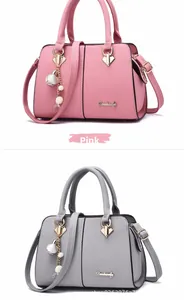 Detailed view of pink and grey Boston bags with lychee grain and pearl pendants