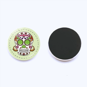 Detailed view of the 25mm round sugar skull glass fridge magnet with magnetic back