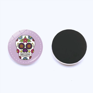 Detailed front and back view of a colorful sugar skull round glass fridge magnet with magnetic back